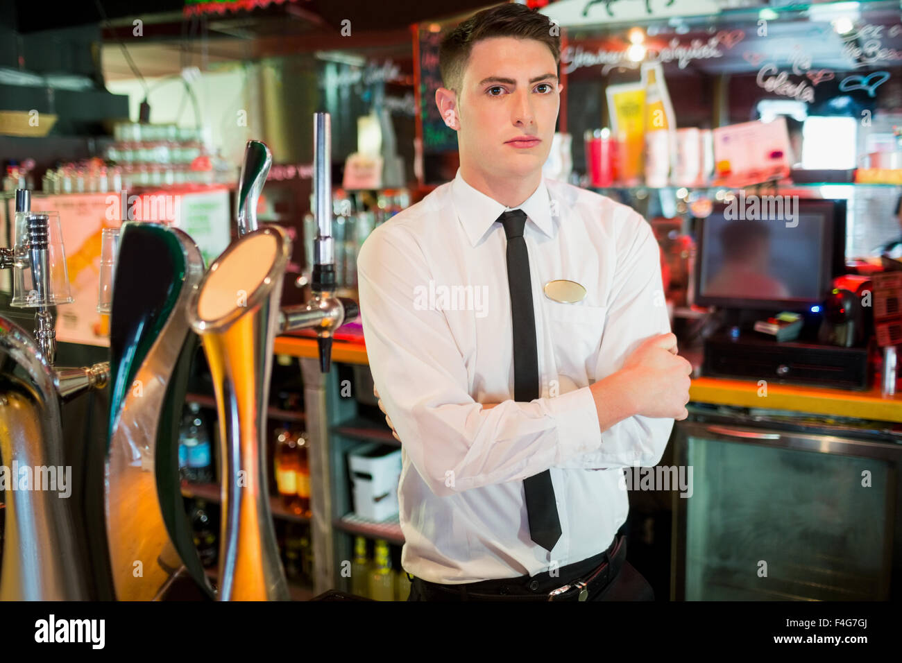 Bien habillé barman avec bras croisés Banque D'Images