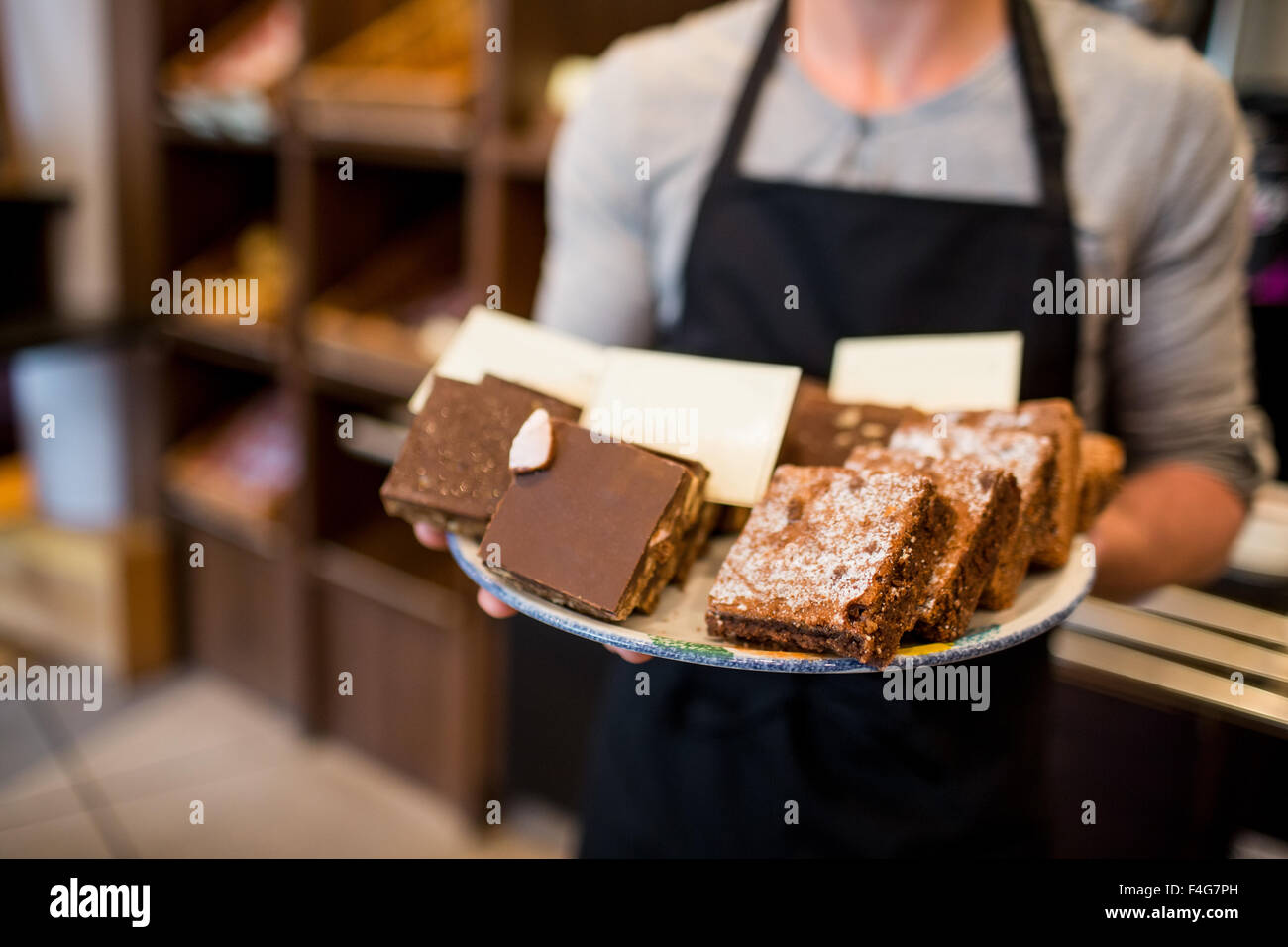Waiter offering brownies de plaque Banque D'Images