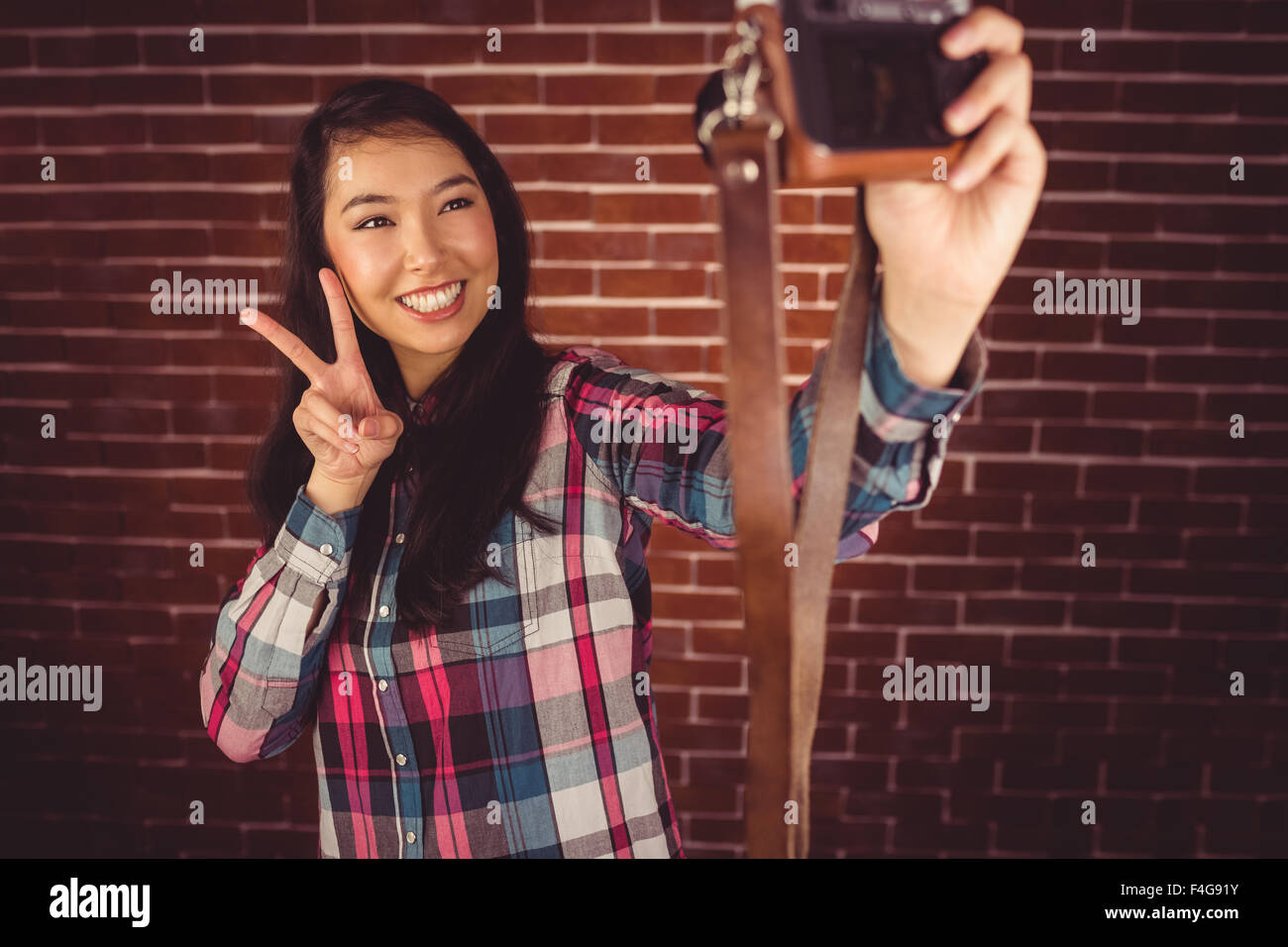 Hipster attrayant gesturing peace sign Banque D'Images