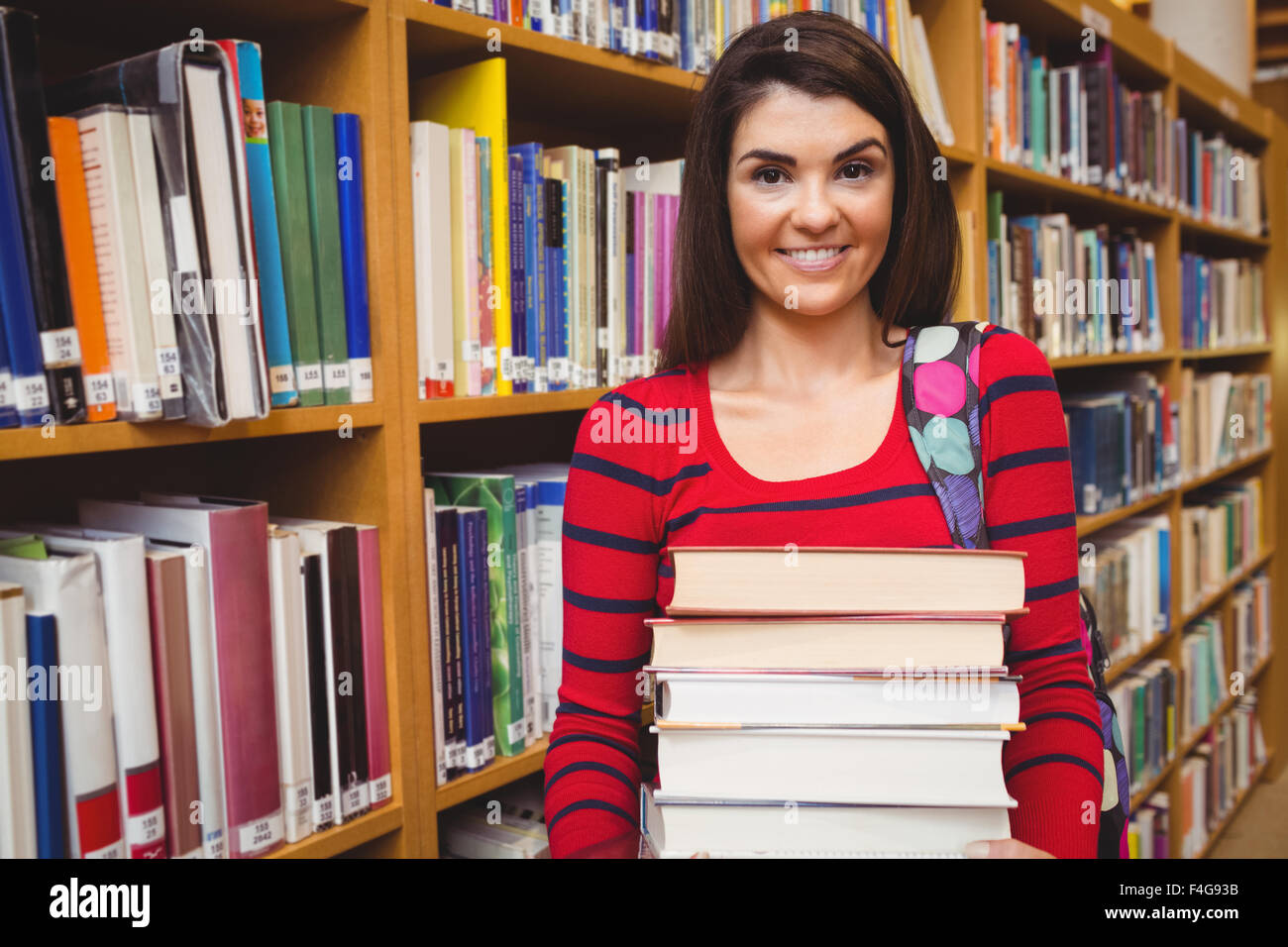 Portrait of cheerful student holding pile de livres Banque D'Images
