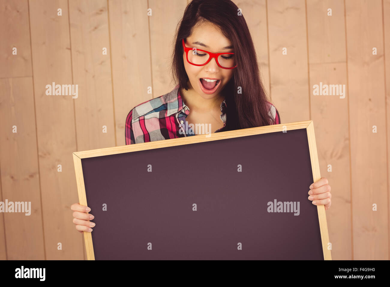 Belle jeune hipster holding blank blackboard Banque D'Images