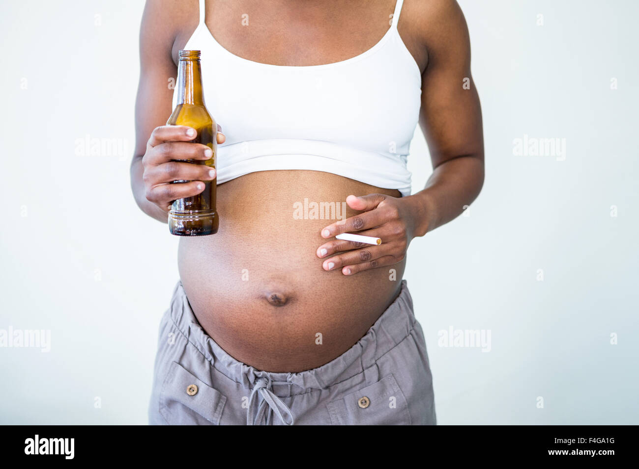 Pregnant woman holding l'alcool et les cigarettes Banque D'Images