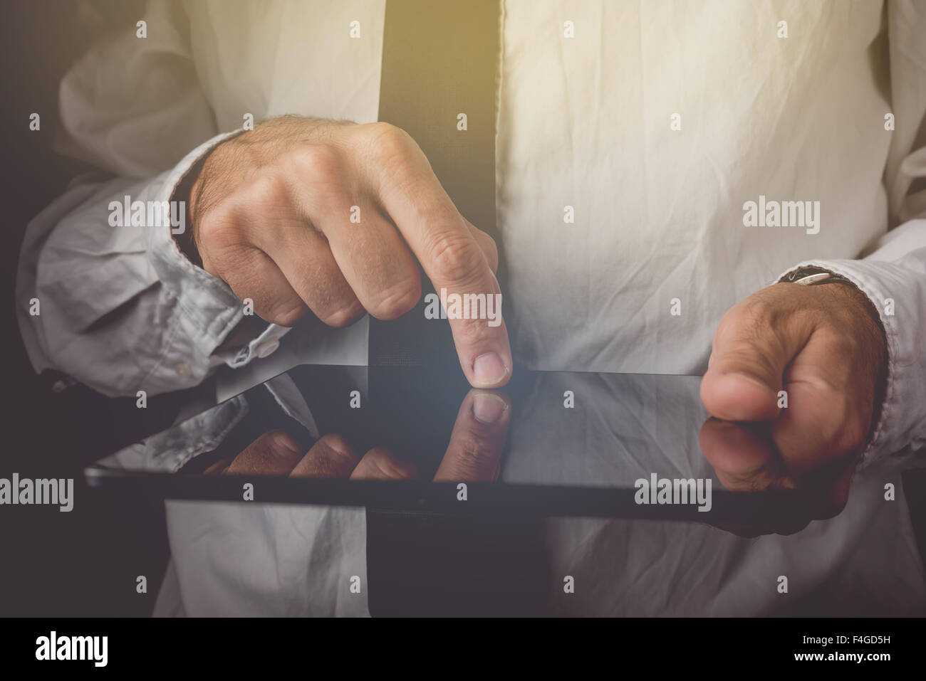 Businessman working on laptop computer, doigt sur l'écran tactile de l'appareil sans fil, l'image aux couleurs rétro, selective focus Banque D'Images