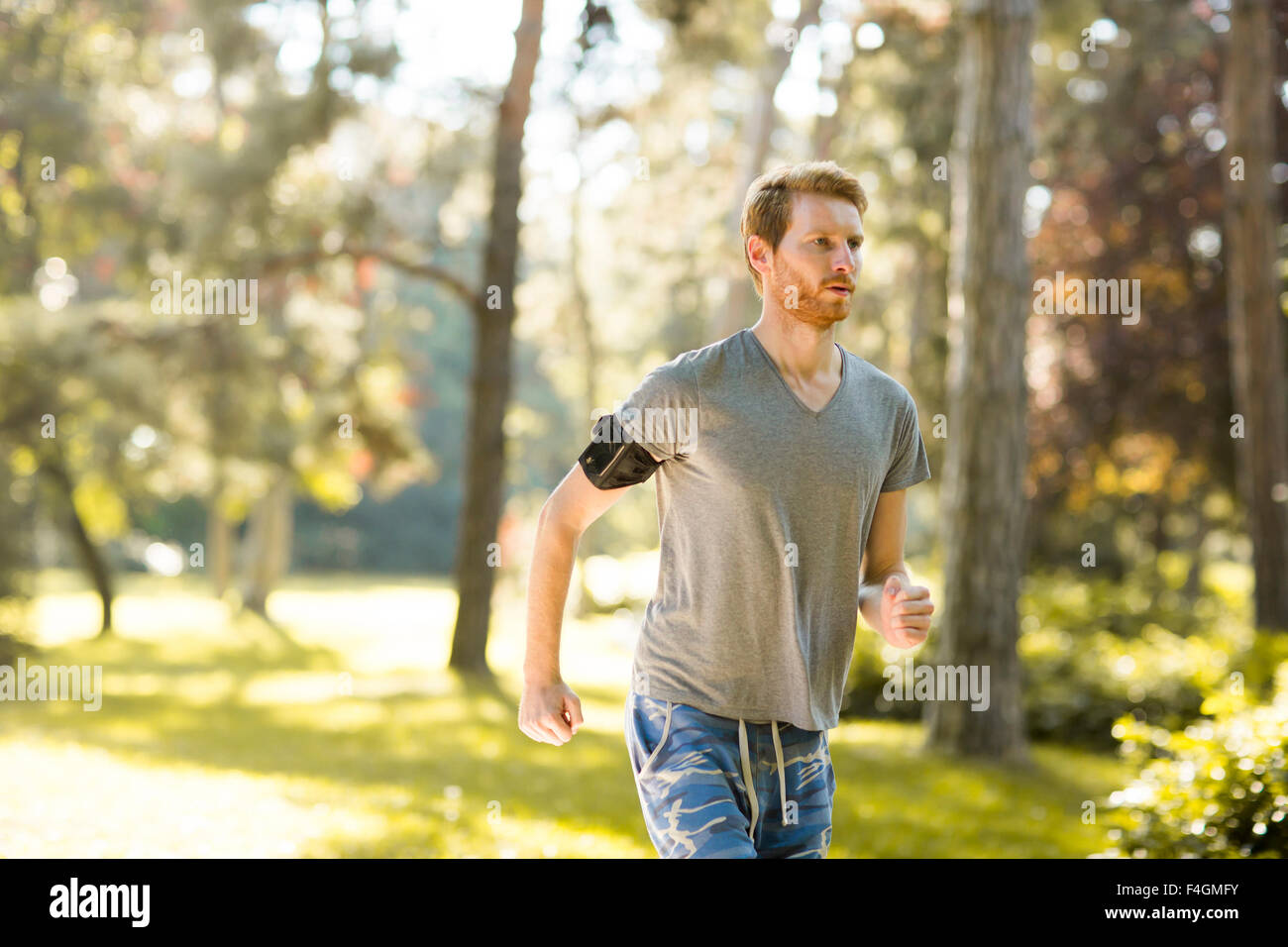Jeune homme d'exécution dans le parc en automne Banque D'Images