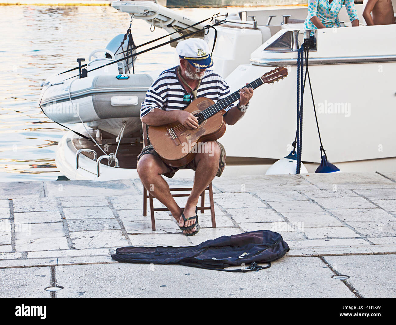 Trogir, Croatie - sur la promenade, un ours de mer effectue le chant vieux marin chansons accompagné de sa guitare Banque D'Images