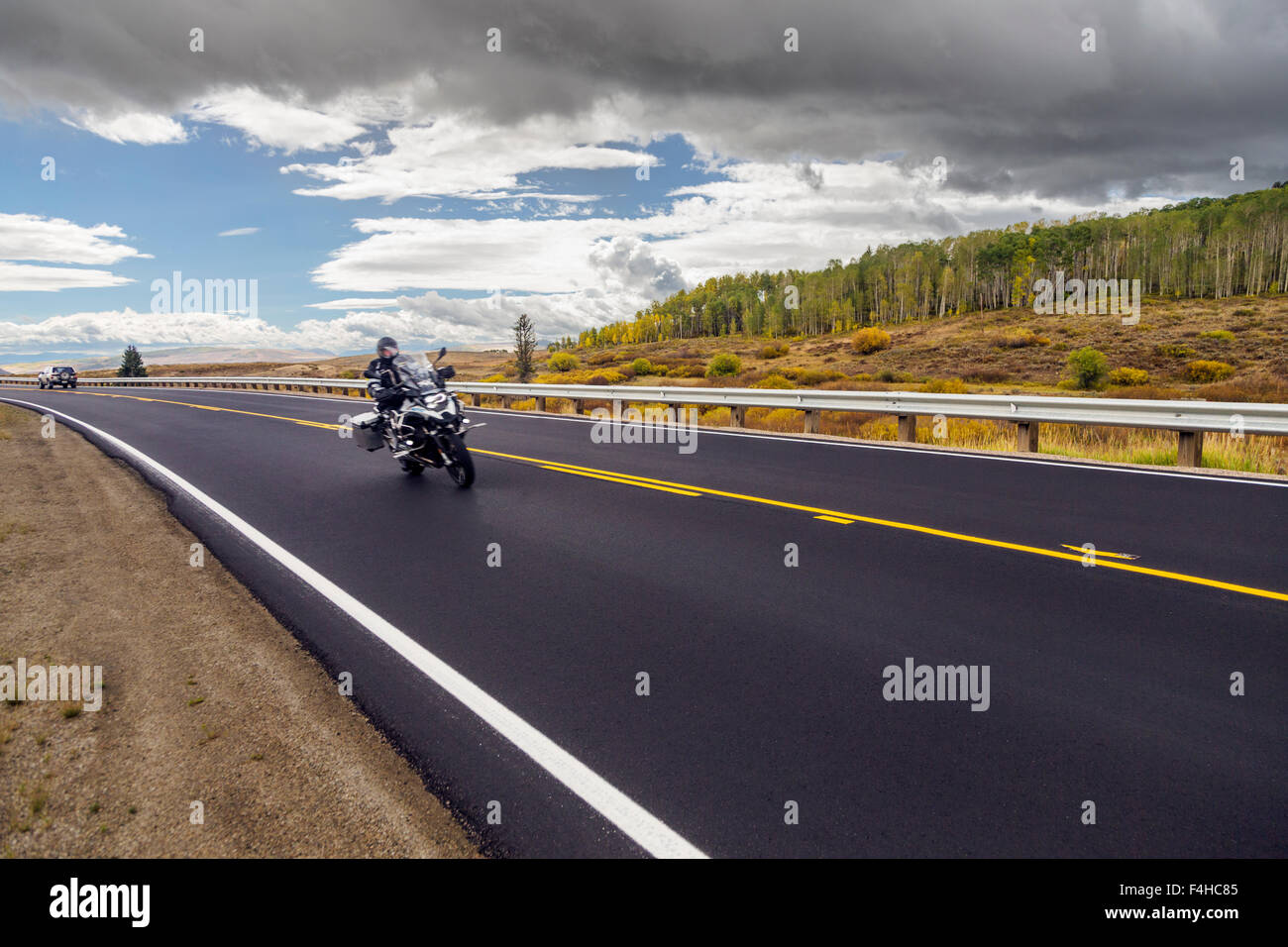 Pilote moto sur route pavée ; l'autoroute 40 Nord ; le centre du Colorado, USA Banque D'Images