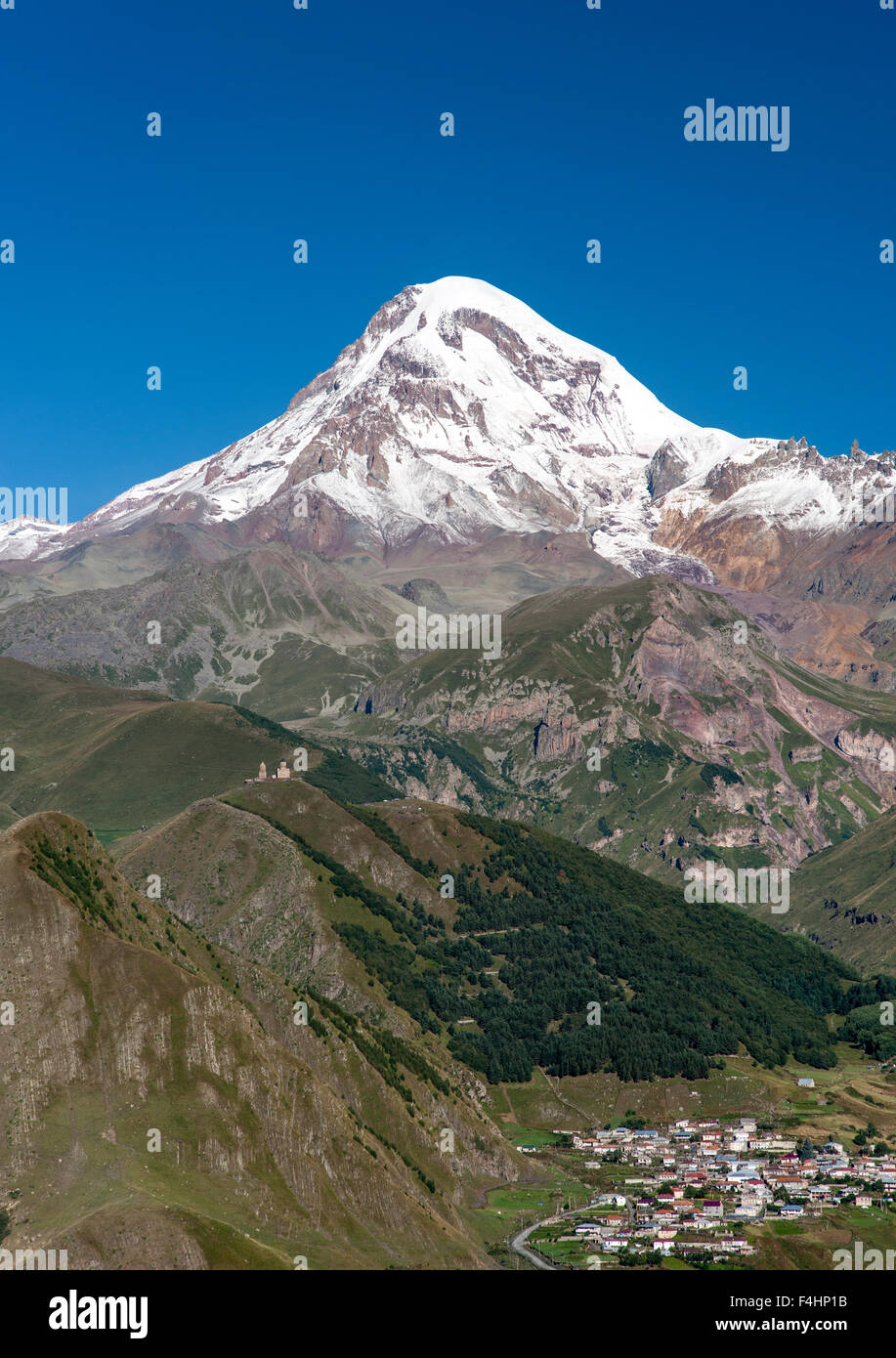 Le mont Kazbek (5047m), le village de l'église de trinité Gergeti Gergeti et dans les montagnes du Caucase du nord de la Géorgie. Banque D'Images