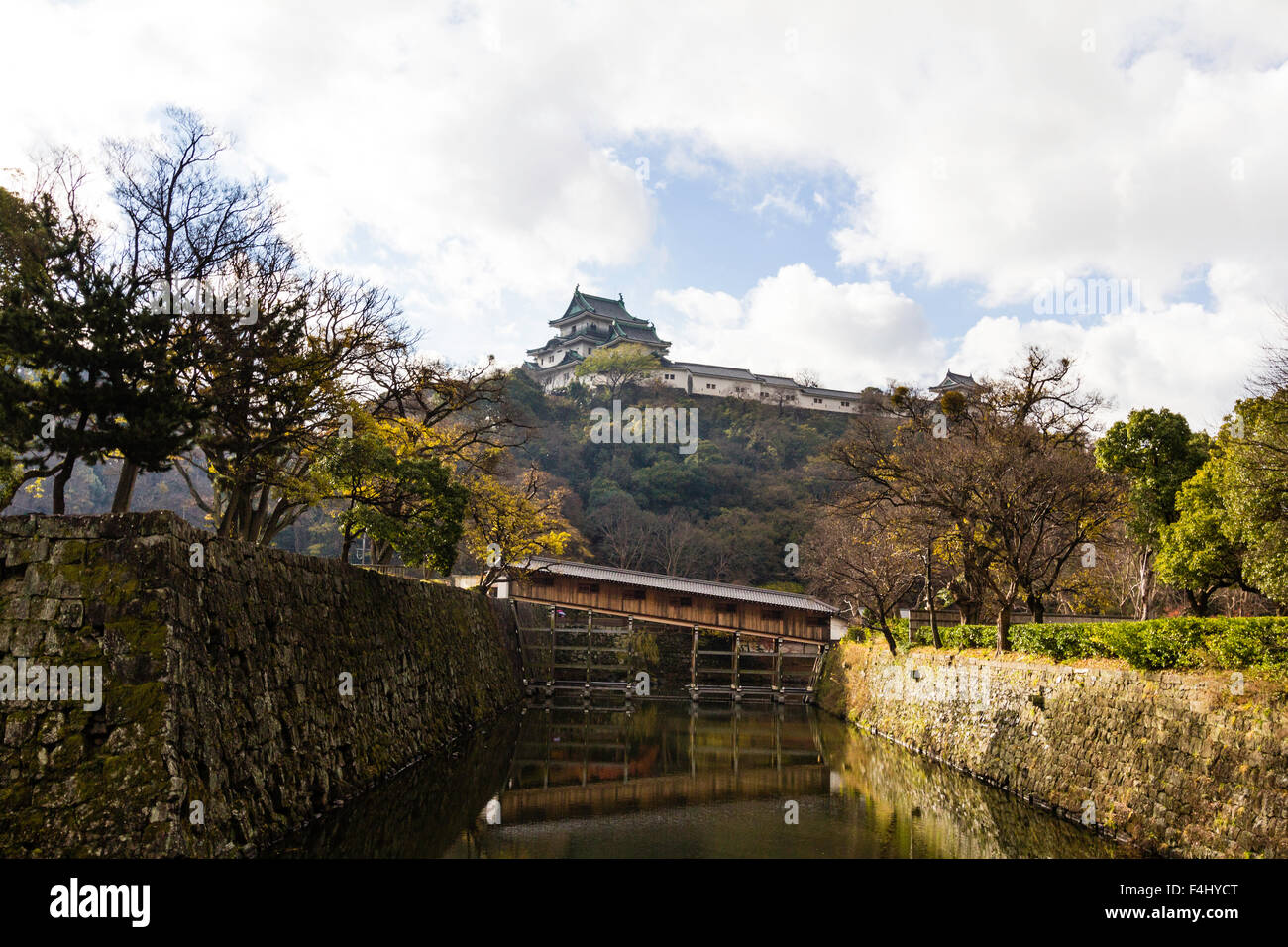 Le Japon, château de Wakayama. Ohashiroka, pont reconstruit un rare exemple d'un pont au clos couvert fossé, se garder d'une colline en arrière-plan. Banque D'Images
