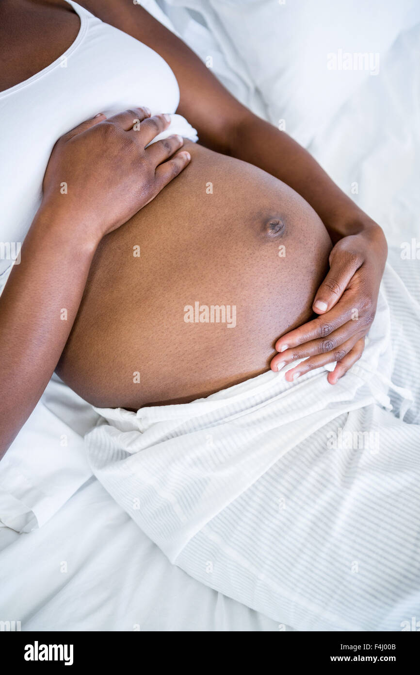 Pregnant woman sitting in bed Banque D'Images