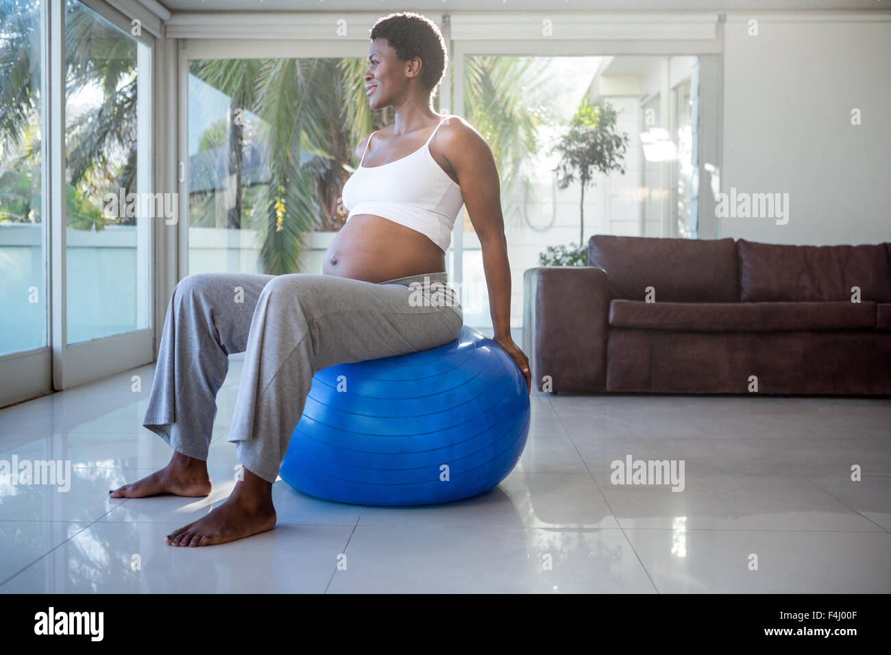 Pregnant woman sitting on exercise ball et à l'écart Banque D'Images