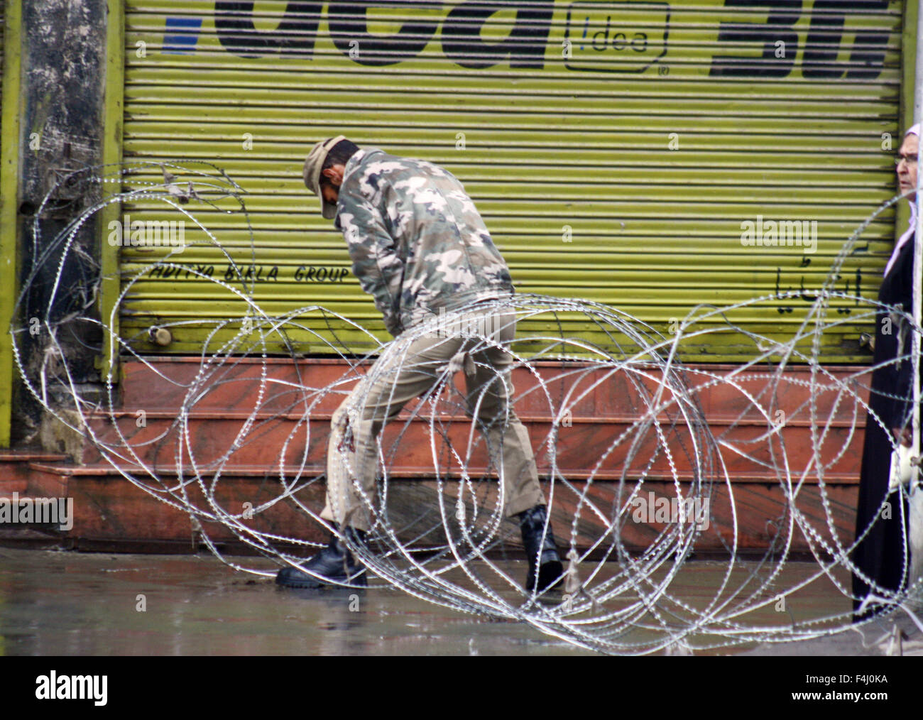 Srinagar, Cachemire sous administration indienne. 19 Oct, 2015. Srinagar, Cachemire indien:19 Octobre.Un cachemiriennes se trouve près de barbelés définit comme policiers indiens pris dans les barbelés pendant les restrictions .les groupes séparatistes ont appelé à un arrêt au Cachemire pour protester contre la mort d'un chauffeur de camion qui a été attaqué avec un cocktail Molotov à Udhampur suite à des rumeurs autour de viande bovine il y a 10 jours. La police a limité les déplacements dans certaines régions de Srinagar après des heurts ont éclaté hier, quelques heures après la nouvelle de la mort de Zahid Ahmad. Credit : Sofi suhail/Alamy Live News Banque D'Images