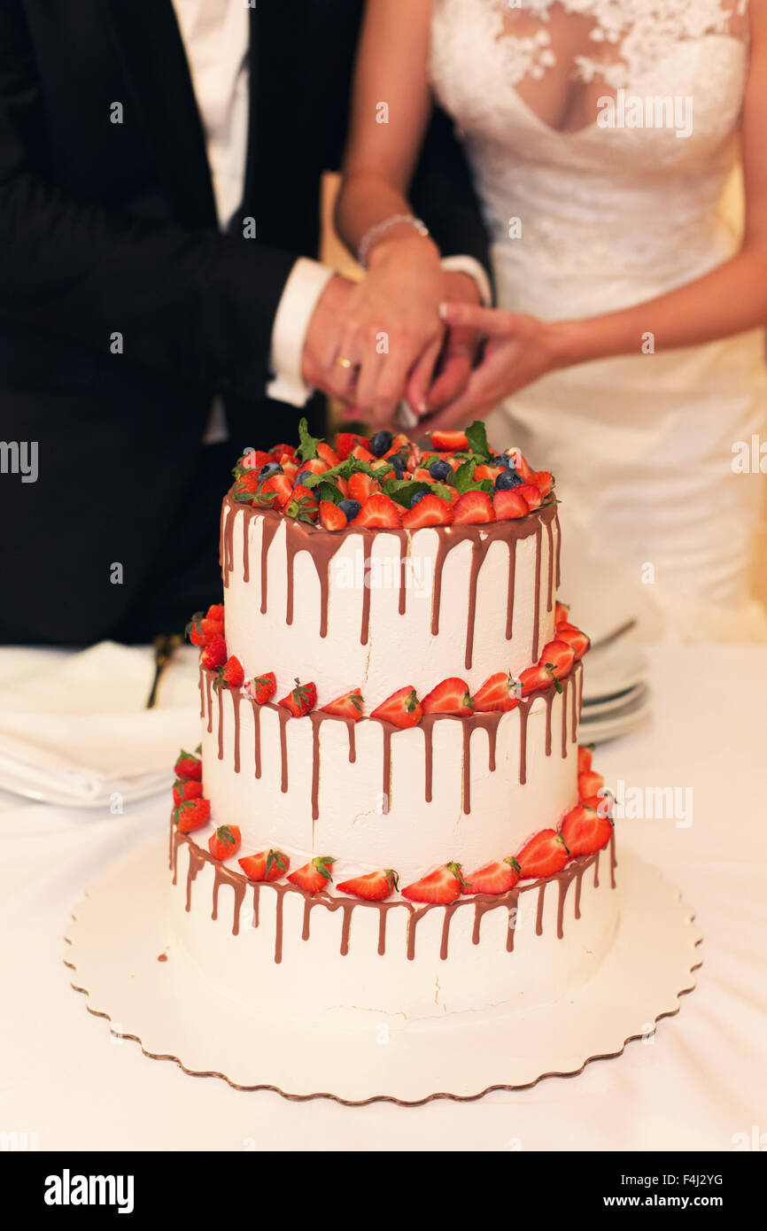 Le couple couper le gâteau de mariage Banque D'Images Le couple couper le gâteau de mariage Banque D'Images