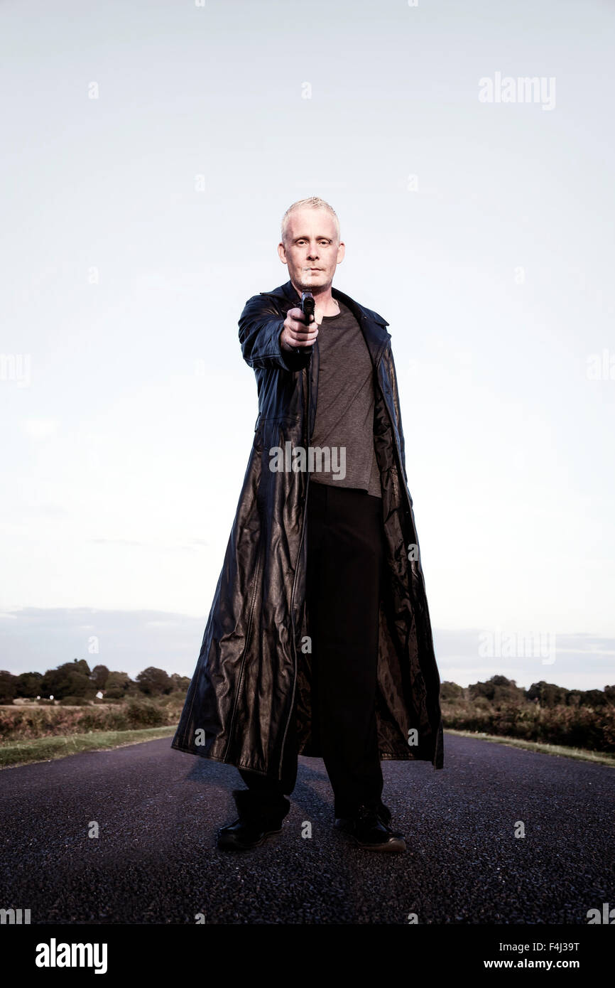 Un homme avec un fusil, visant à l'appareil photo Banque D'Images