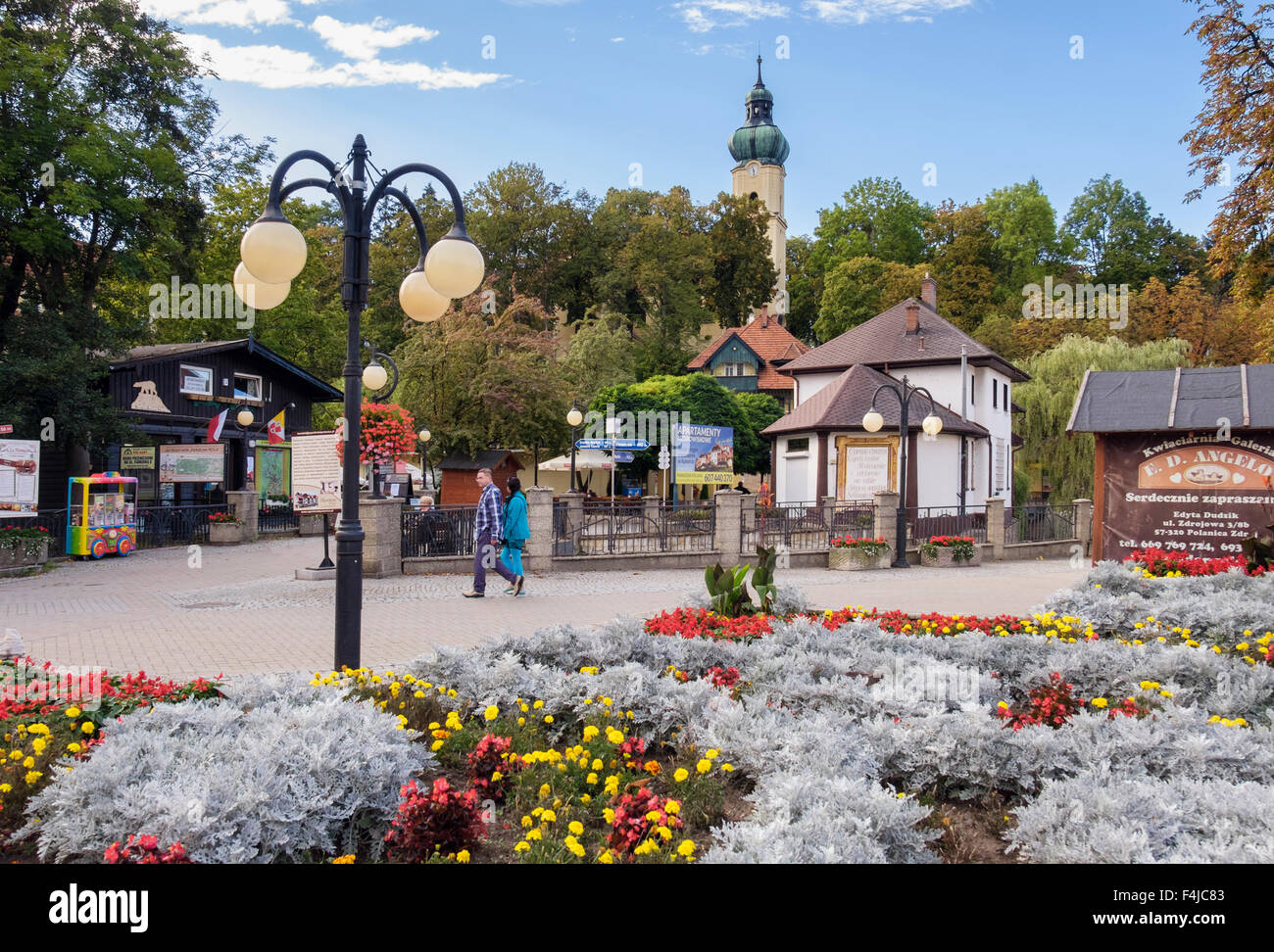 Jolie rue piétonne en plein centre de station thermale du piémont avec l'église paroissiale de l'Assomption au-delà. Polanica-Zdroj, Pologne Banque D'Images