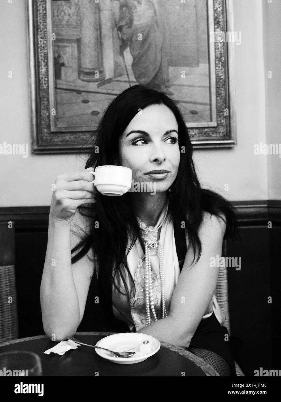 France, Paris, young woman drinking coffee in cafe Banque D'Images