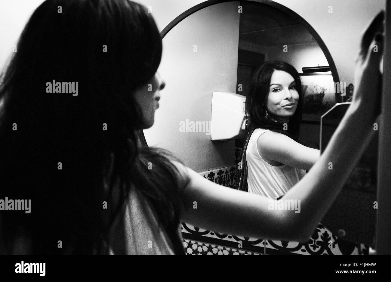 France, Paris, portrait of mid adult woman wearing plume boa reflétant en miroir Banque D'Images