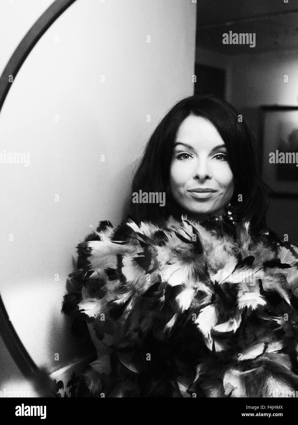 France, Paris, portrait of mid adult woman wearing plume boa reflétant en miroir Banque D'Images