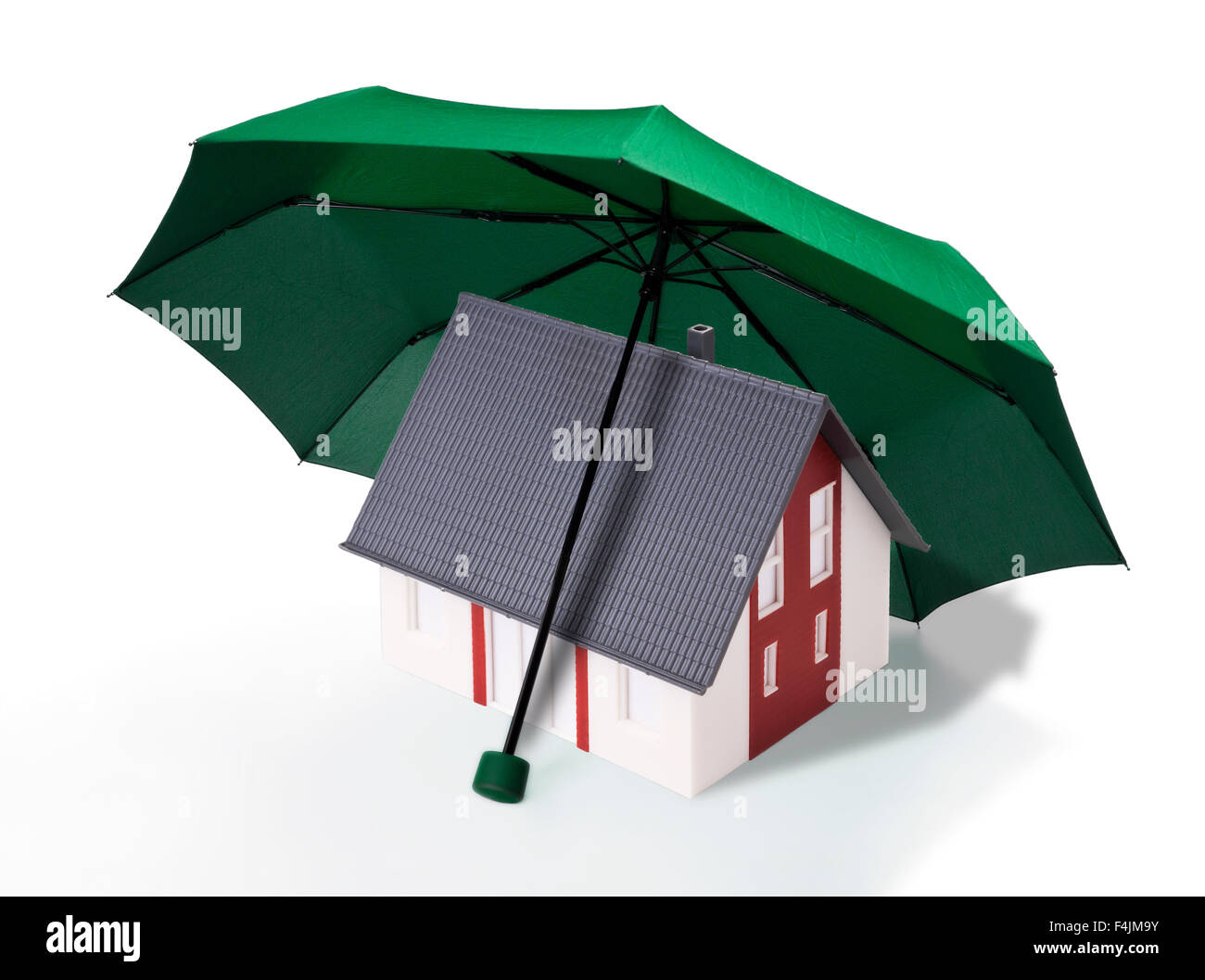La maison est protégée par un parapluie vert. Banque D'Images