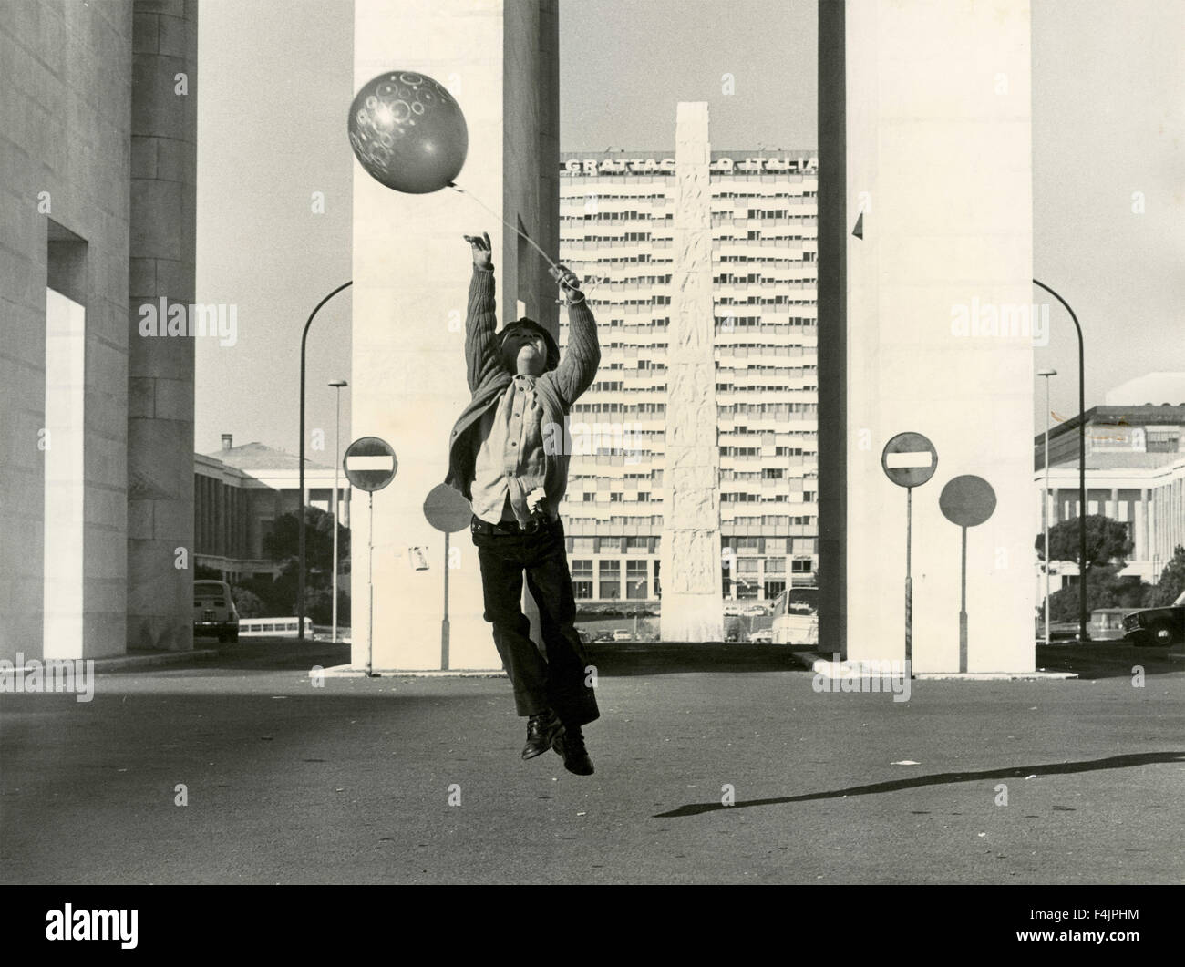 Enfant joue avec un ballon en EUR, Rome, l'obélisque, Piazza dell'Agricoltura Banque D'Images