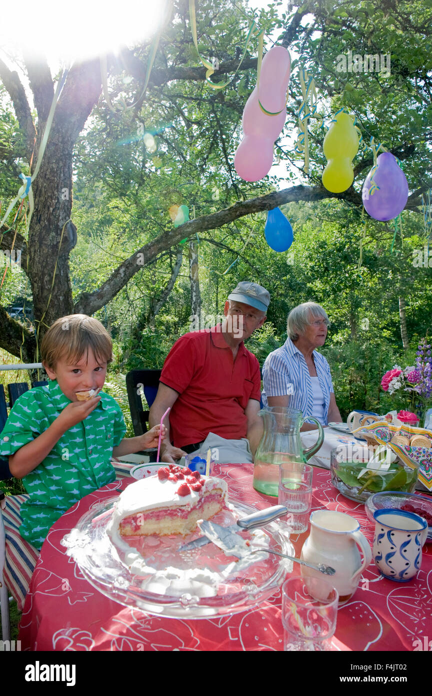 Boy eating cake at Birthday party Banque D'Images