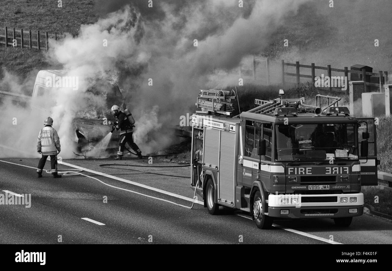 Les pompiers éteindre un incendie van sur l'autoroute Banque D'Images