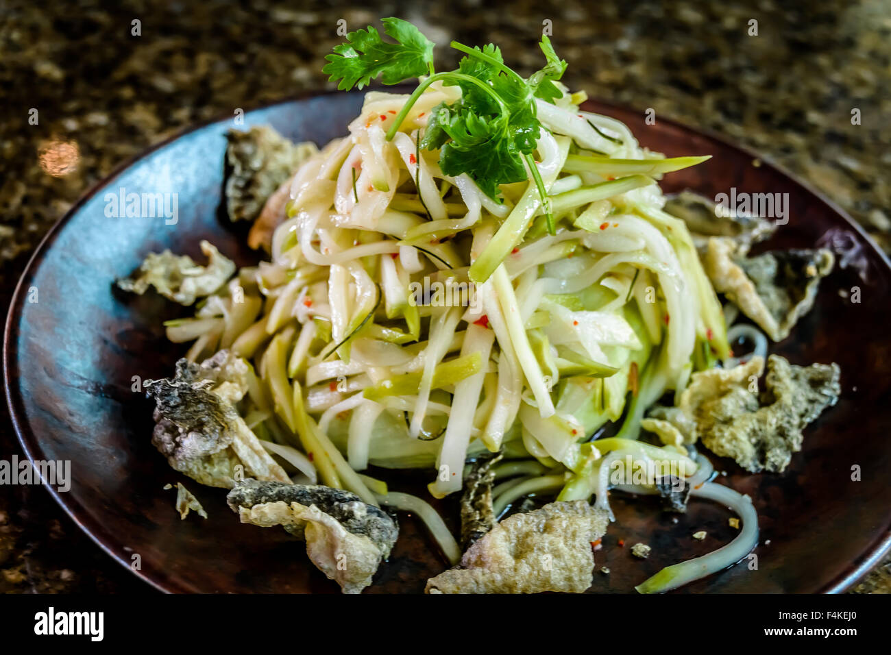 Salade de mangue verte avec des peaux de poisson croustillant. Banque D'Images