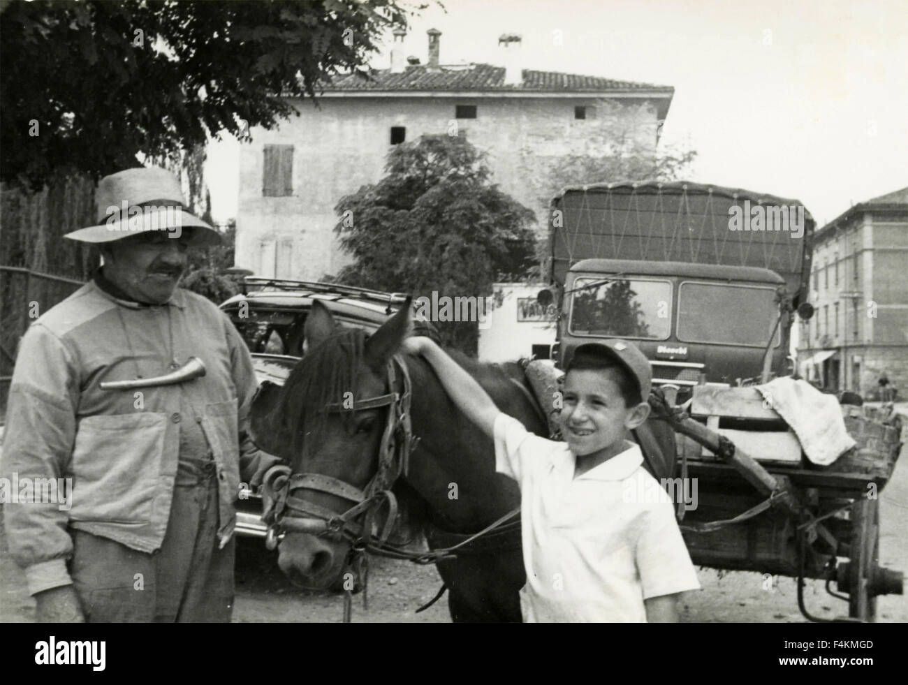 Garçon à côté d'un chariot tiré par un âne, Italie Banque D'Images
