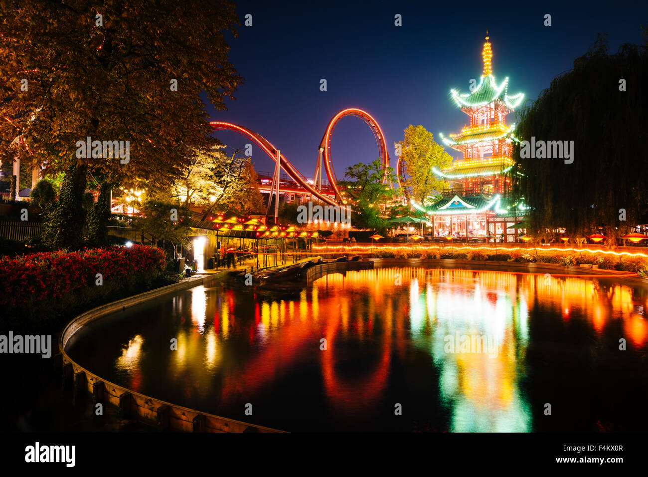 La Tour japonaise et de manèges de nuit, ce qui reflète en un lac à Tivoli Gardens, à Copenhague, au Danemark. Banque D'Images