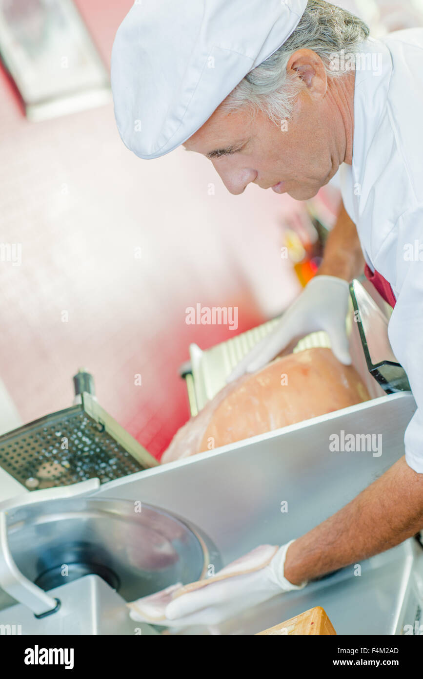 Man slicing machine avec de la viande Banque D'Images