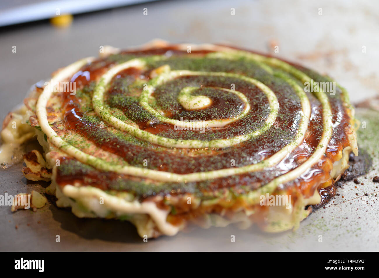 Okonomiyaki japonais sur la plaque chaude Banque D'Images