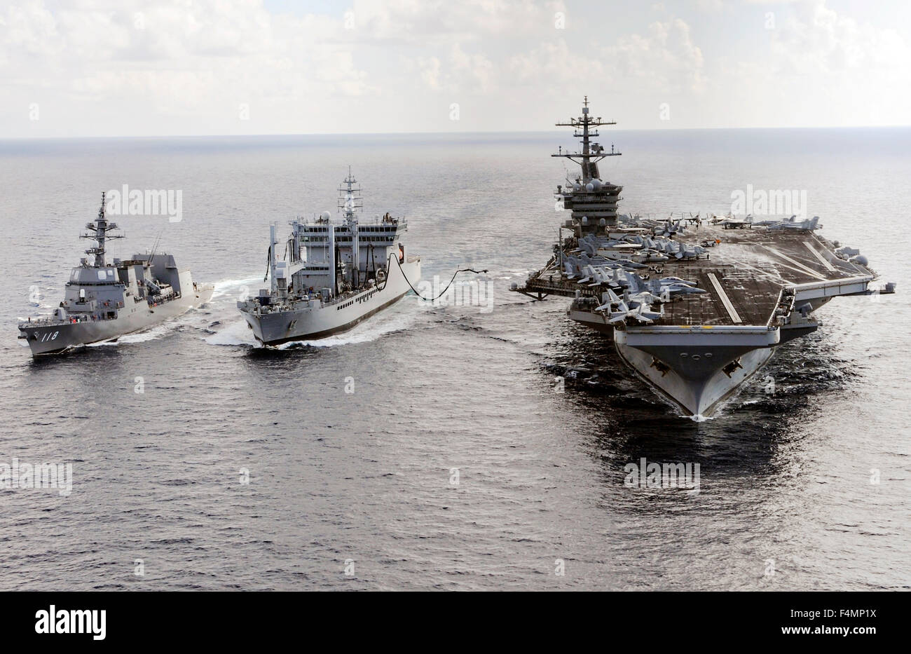 Classe Nimitz US Navy porte-avions USS Theodore Roosevelt et d'auto-défense maritime japonais Akizuki destroyer de classe Force-JS Fuyuzuki voiles aux côtés de l'Indien Deepak-flotte classe tanker INS Shakti au cours d'un ravitaillement en mer une partie de l'exercice le 18 octobre 2015, Malabar dans l'Océan Indien. Banque D'Images