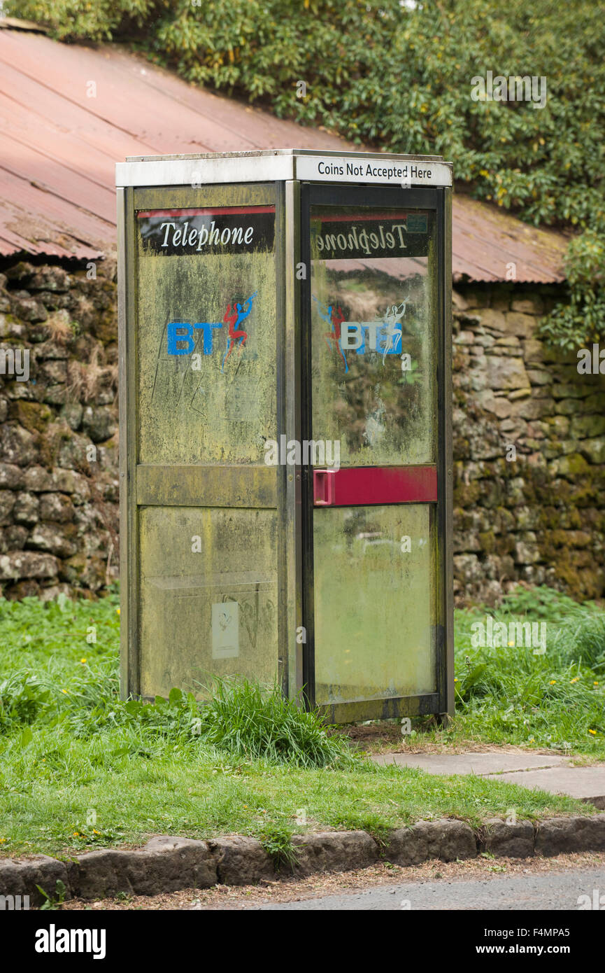 Un KX100 téléphone fort au bord de la route en milieu rural North Yorkshire, Angleterre, Royaume-Uni. Ce kiosque a sale, les éclaboussures de boue et de windows logo BT -il est vide. Banque D'Images