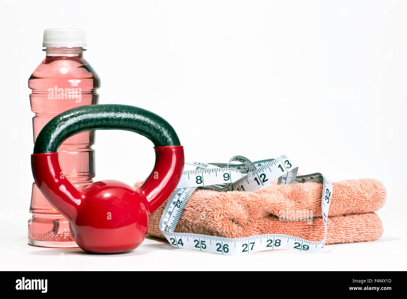 Poids d'entraînement rouge avec boisson pour sportifs, serviette, rose et ruban à mesurer pour illustrer la condition physique des femmes. Banque D'Images