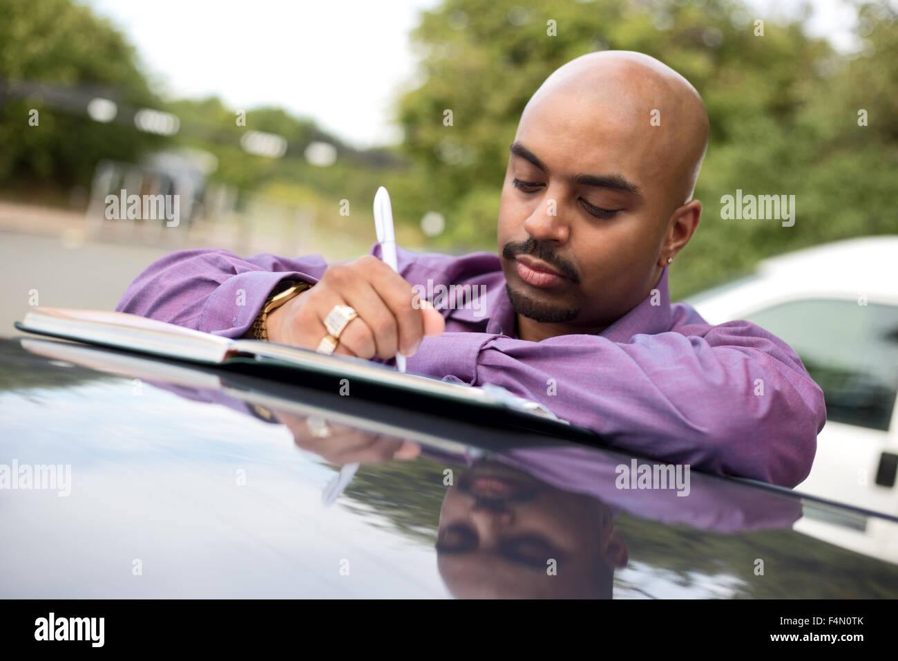 Jeune homme à écrire des notes dans un livre Banque D'Images
