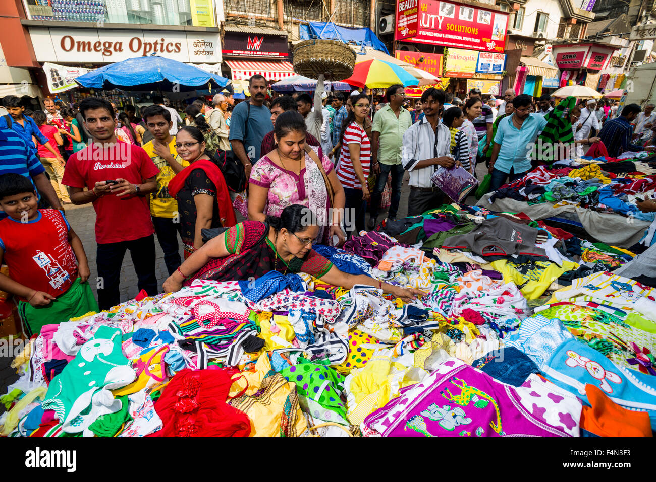 Vendeurs proposent des vêtements à vendre dans une rue bondée de boutiques au marché mangaldas Banque D'Images