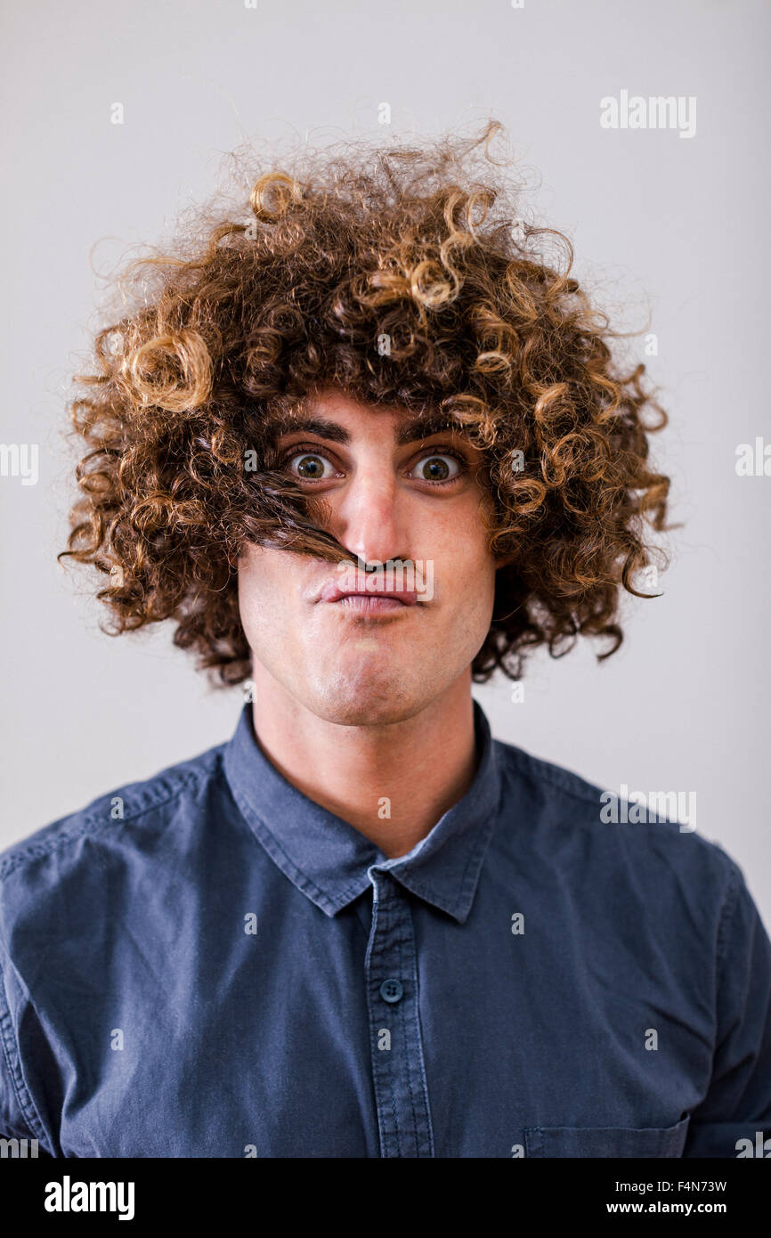 Portrait d'un homme avec les cheveux frisés et mèche de cheveux comme  moustache Photo Stock - Alamy