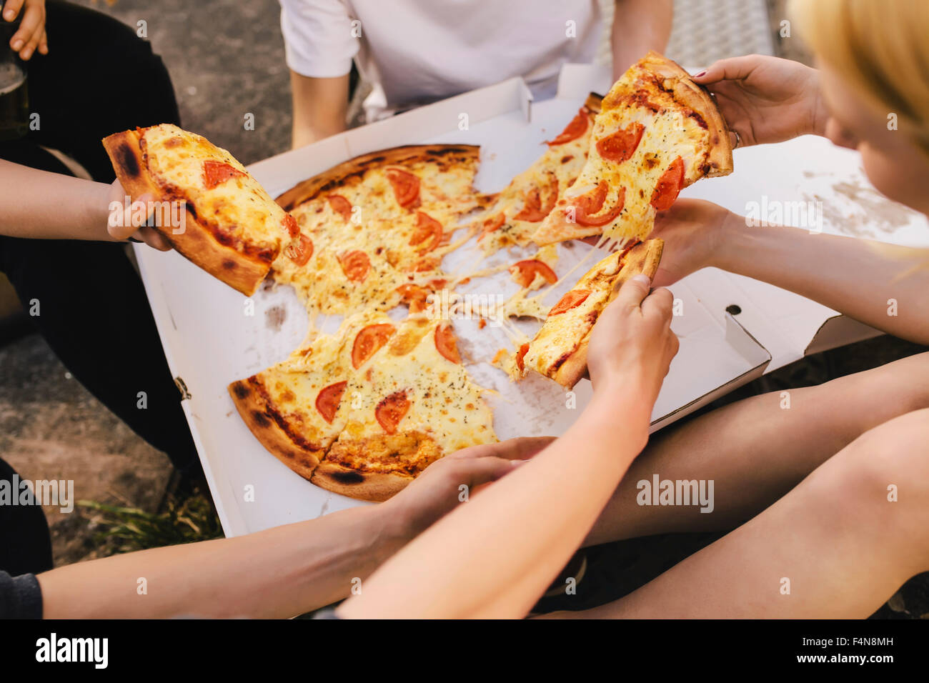 Les amis partageant une pizza Banque D'Images
