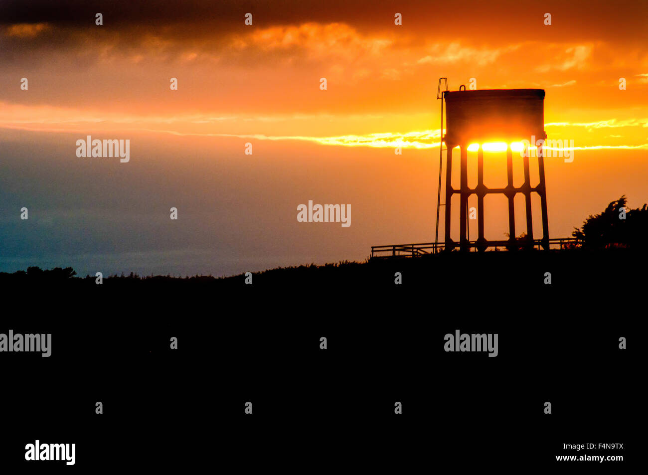 Coucher de soleil derrière un château d'eau dans le village de Pennard, Gower, Galles du sud. Banque D'Images