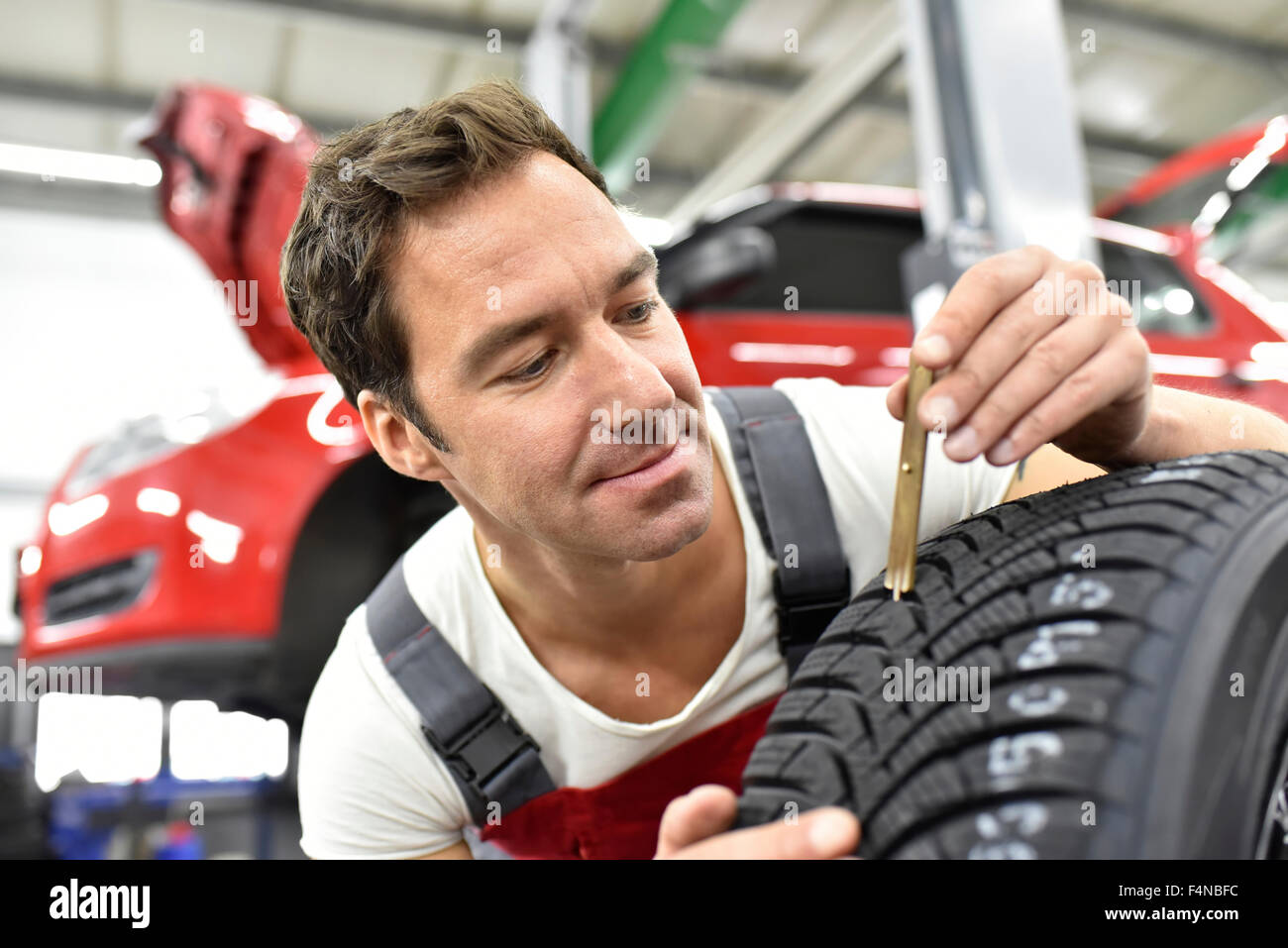 Mécanicien automobile travaillant dans un garage de réparation, de contrôle de profondeur de modèle Banque D'Images