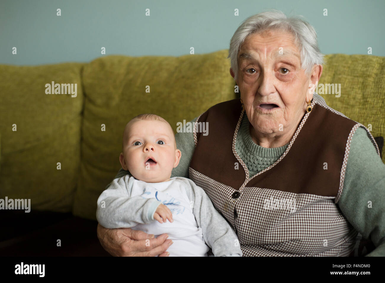 Vieille Femme et son petit-fils assis sur le canapé Banque D'Images