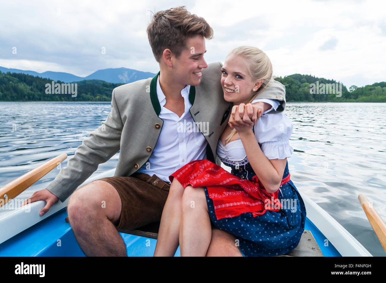 Allemagne, Bavière, jeune couple assis dans un bateau à rames sur Staffelsee Banque D'Images