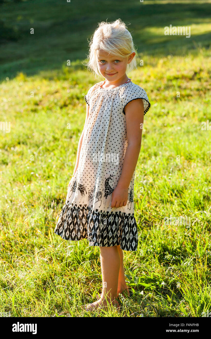 Portrait of smiling blonde petite fille portant tenue d'été l'article sur un pré Banque D'Images