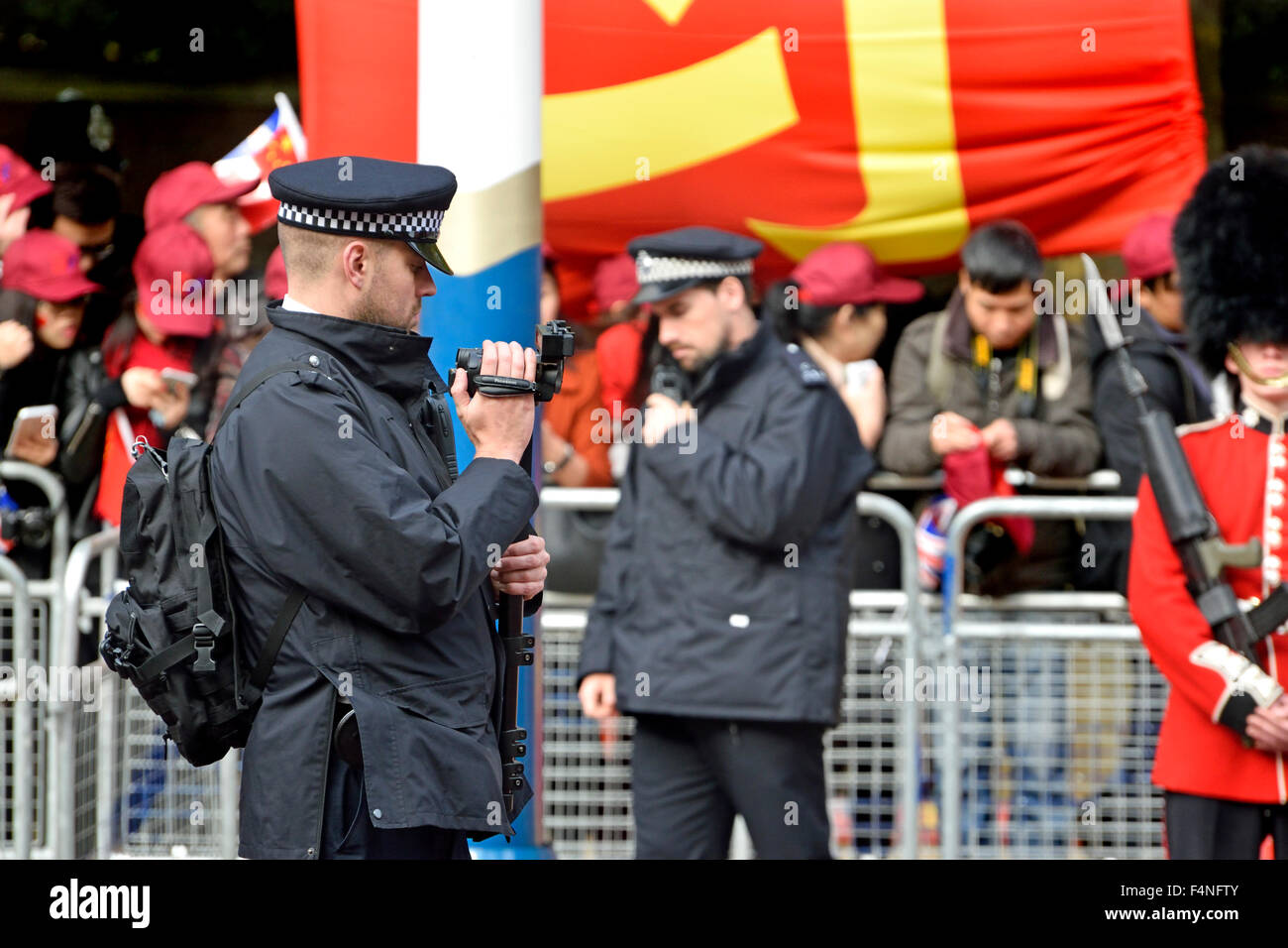 Londres 2015 : agent de police de filmer la foule et les manifestants pendant le président chinois Xi Jinping en visite à Londres Banque D'Images