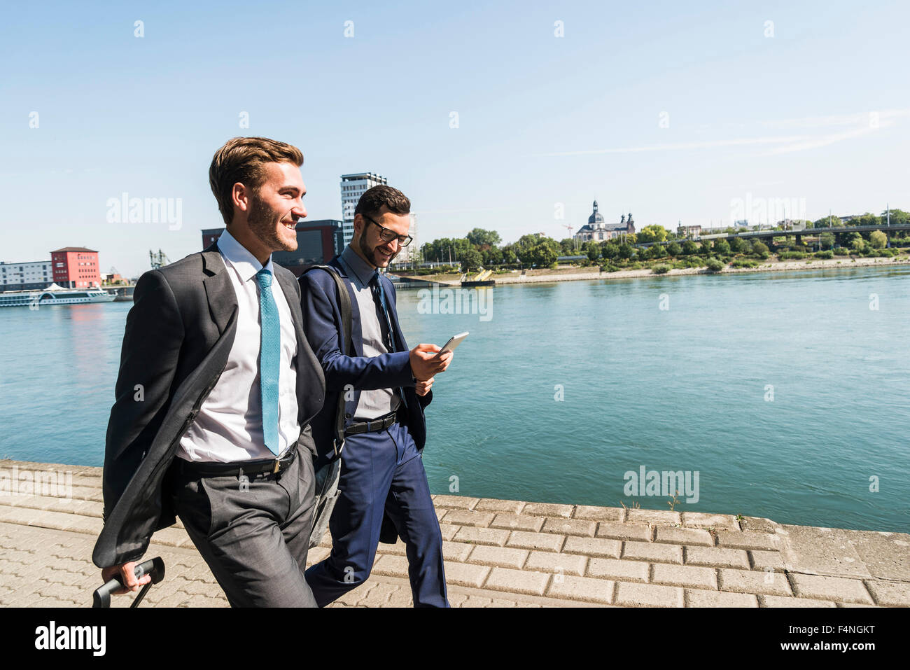Deux jeunes hommes d'affaires en voyage d'affaires, de marcher par river Banque D'Images
