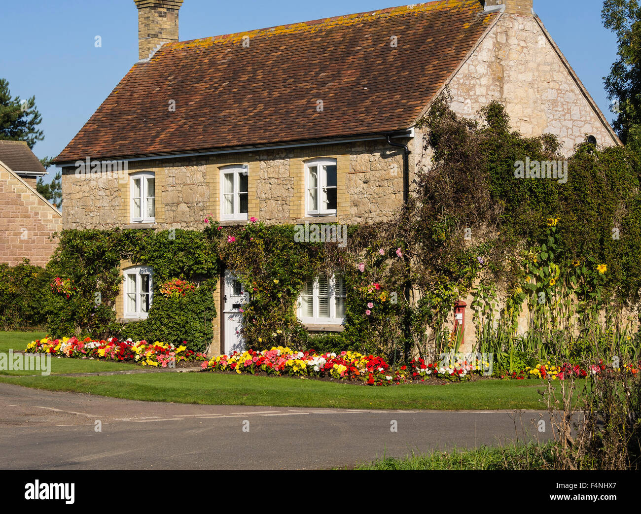 Maison de campagne avec des arbustes et plantes colorées border à Newtown, île de Wight, Angleterre, RU Banque D'Images