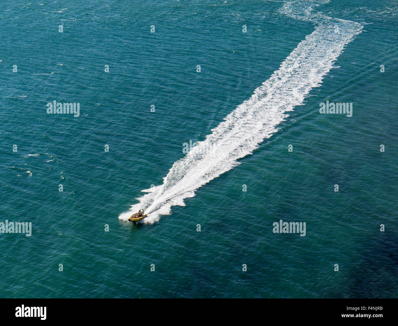 Bateau gonflable accélérant sur la mer laissant une traînée de mousse blanche dans son sillage, Solent, île de Wight, Angleterre, RU Banque D'Images
