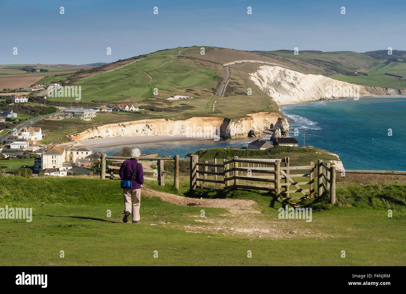 Walker sur le sentier près de la Baie d'eau douce Tennyson avec Afton et Compton Vers le bas en arrière-plan, l'île de Wight, Angleterre, RU Banque D'Images