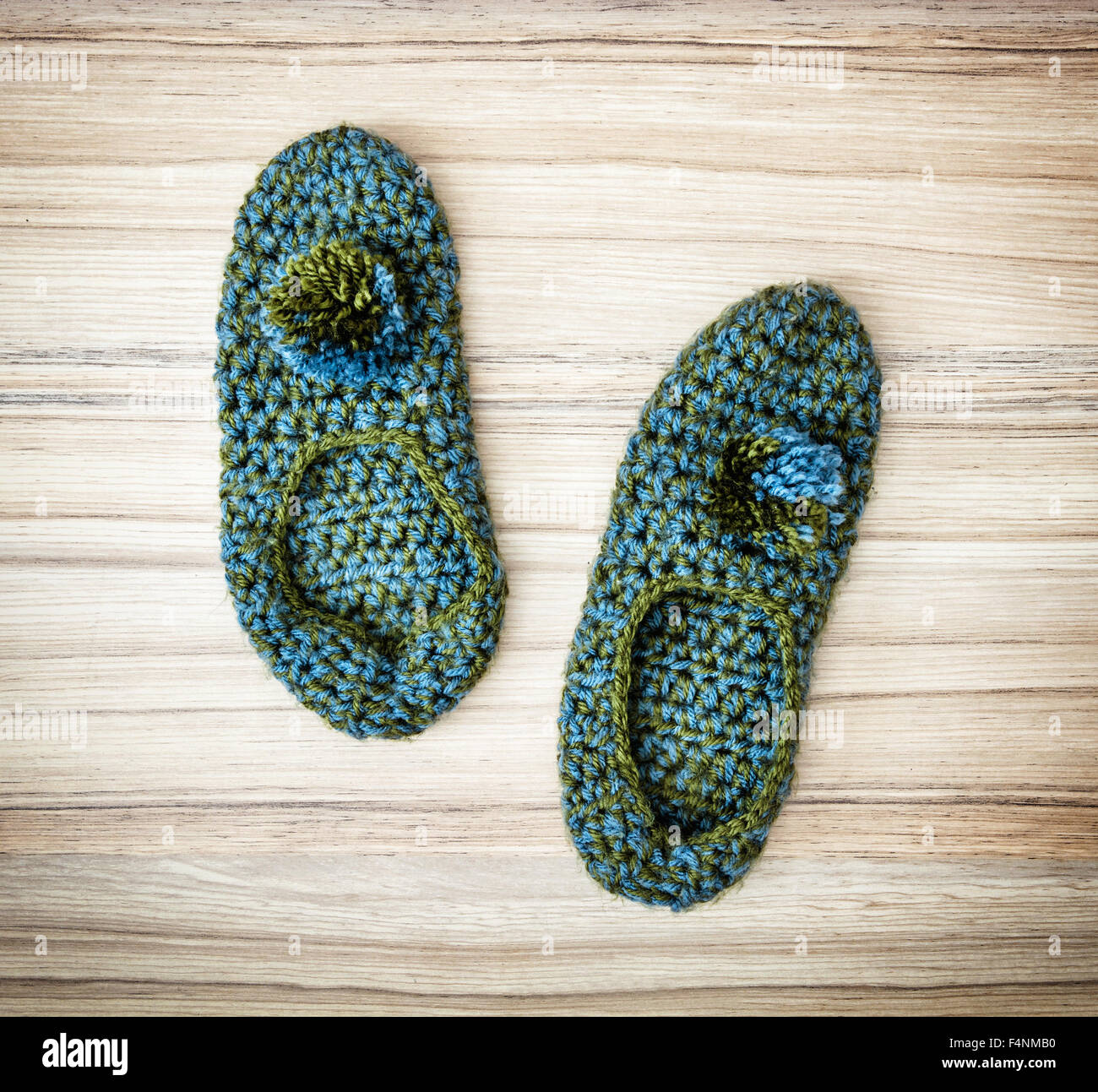 Vert-bleu chaussons tricotés sur le fond en bois. La mode d'automne. Banque D'Images