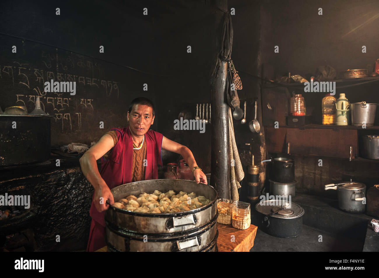 Monk est la préparation des aliments dans la cuisine tibétaine Banque D'Images