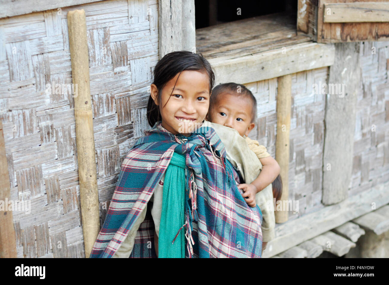 Le Nagaland, Inde - Mars 2012 : cute little girl porte son jeune frère sur son dos au Nagaland, région reculée de l'Inde. Docu Banque D'Images